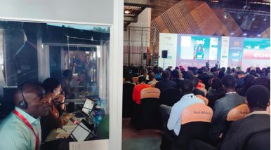 Interpreter at work in booth overlooking a conference hall